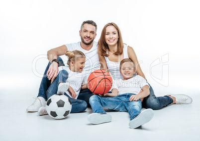 Cheerful family with soccer and basketball balls