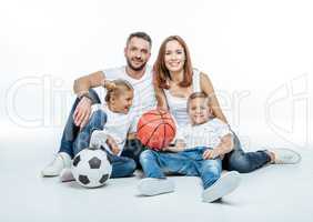 Cheerful family with soccer and basketball balls