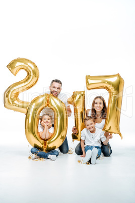Happy family holding golden balloons