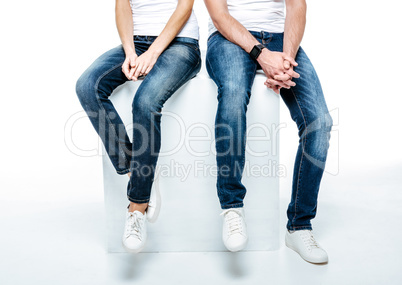 Couple sitting in jeans and white shoes
