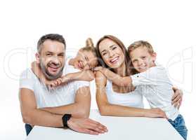 Smiling family in white t-shirts hugging