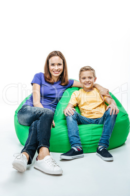 Smiling mother with son sitting in sack-chair