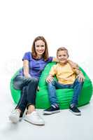 Smiling mother with son sitting in sack-chair