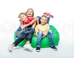Happy mother with children in sack-chair