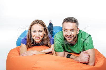 Smiling couple lying in sack-chair