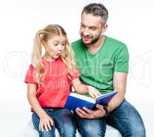 father and daughter sitting and reading book