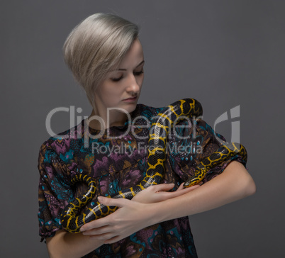 Young woman holding snake