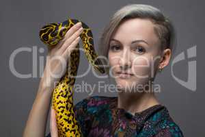 Blond woman holding yellow anaconda