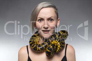 Scared woman with anaconda on her neck