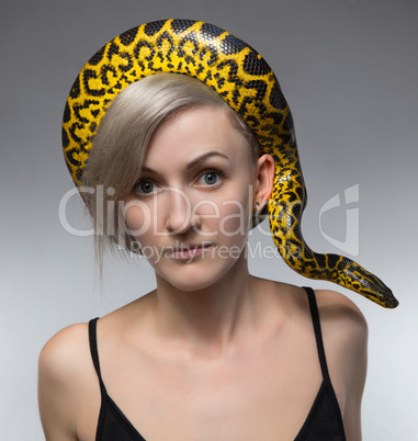Woman and crawling snake on her head