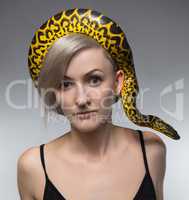 Woman and crawling snake on her head