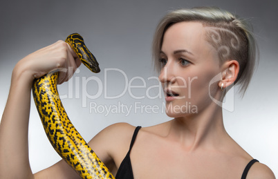 Young woman holding yellow snake