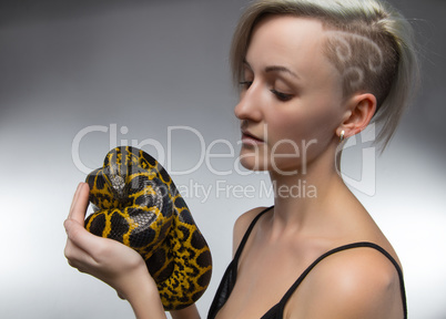 Blond woman holding yellow anaconda