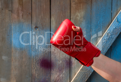 Red leather boxing glove on a woman's hand
