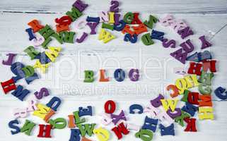 Word blog of small multicolored letters on a white surface