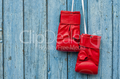 pair of red boxing gloves hanging on a nail