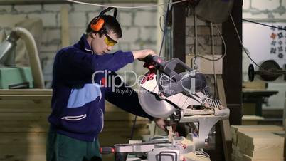 Carpenter cutting wood with sliding mitre saw