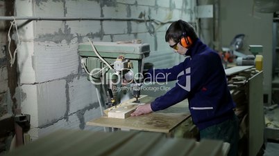 Artisan boring holes in wood with drilling machine