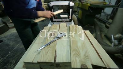 Carpenters planing planks with planing machine