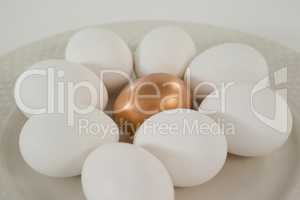 White and golden easter eggs in plate