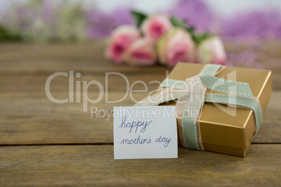 Gift box with happy mother day card on wooden surface