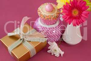 Close-up of gift box, cupcake and flowers vase