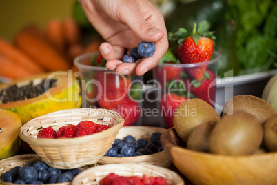 Hand of male staff holding blueberries