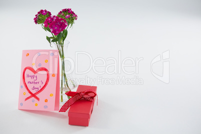 Happy mothers day greetings with gift box and flower vase