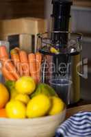 Juicer with carrot and lemon in a bowl