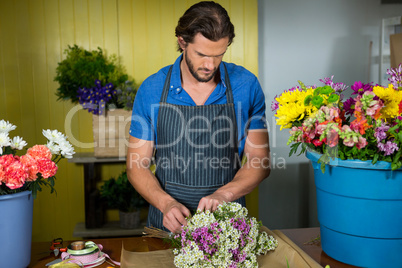 Male florist preparing a flower bouquet