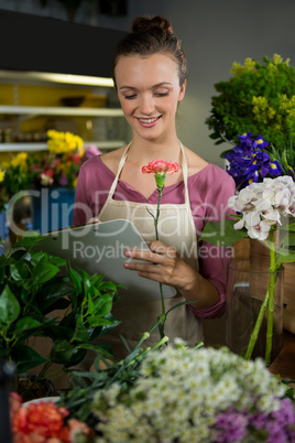 Female florist maintaining record on clipboard