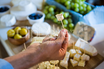 Staff showing a sample of cheese to customer at counter
