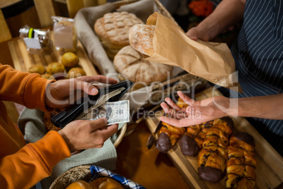 Customer paying bill by cash at bread counter