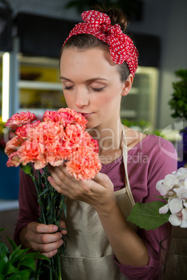 Female florist smelling a bunch of flower