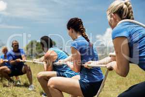 People playing tug of war during obstacle training course