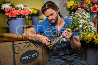 Male florist preparing a flower bouquet