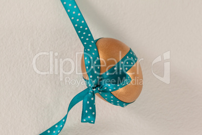 Golden easter egg tied with blue ribbon