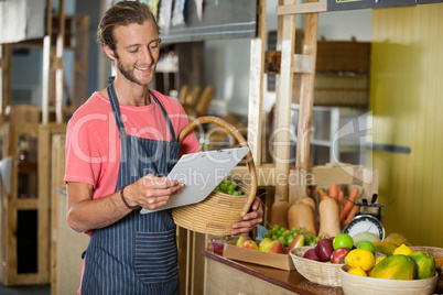 Male staff looking at clipboard in organic section