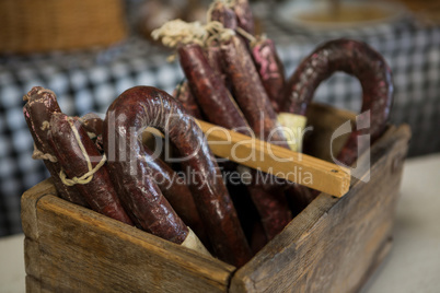 Sausages in wooden basket at counter in market