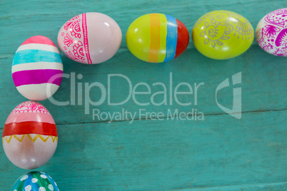 Painted Easter eggs arranged on wooden plank