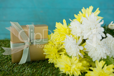 Gift box with flowers on grass