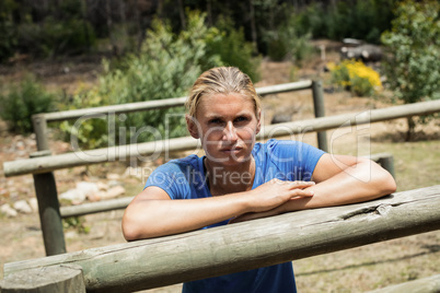 Woman leaning on a hurdle during obstacle course