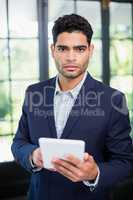 Portrait of businessman holding digital tablet