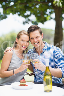 Couple toasting glasses of wine in a restaurant