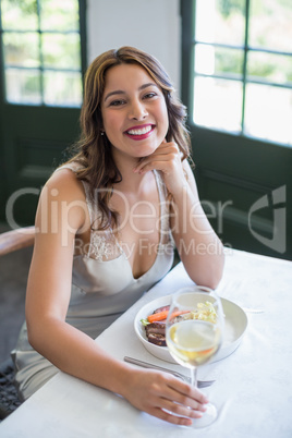 Woman smiling while holding wine glass in the restaurant