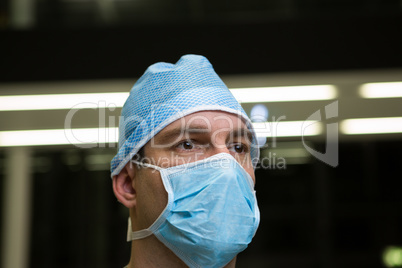 Thoughtful male surgeon wearing surgical mask