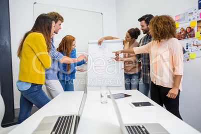 Executives discussing over flip chart board in conference room meeting