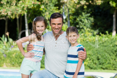Smiling father with his son and daughter at the park