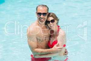 Portrait of romantic couple embracing in smiling pool