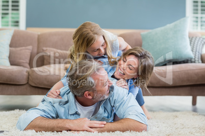 Happy family lying heaped on carpet in living room
